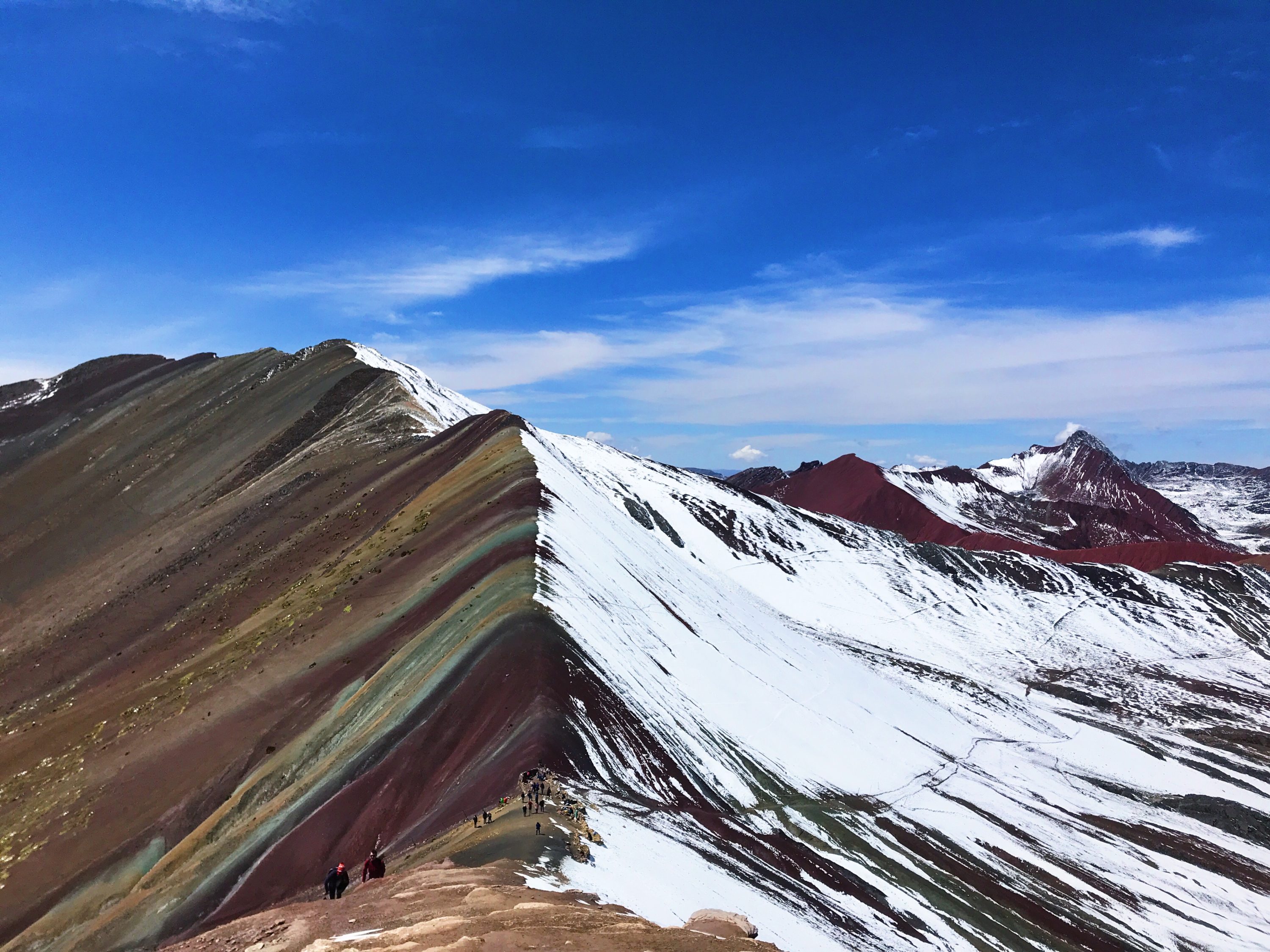 Rainbow Mountain half covered in snow on a sunny day