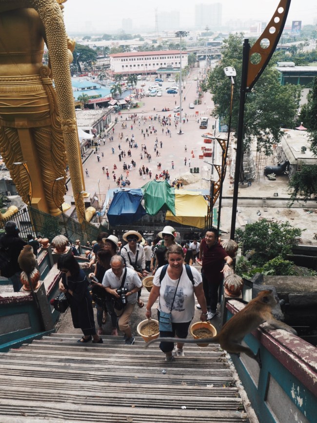 Carrying buckets of sand up to the Temple Cave, Batu Caves